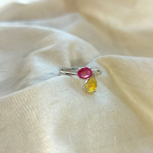 Ring with a red gemstone and a yellow gemstone on a beige fabric background