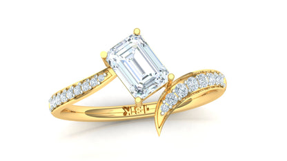 Gold ring with emerald-cut diamond and smaller diamonds on a white background