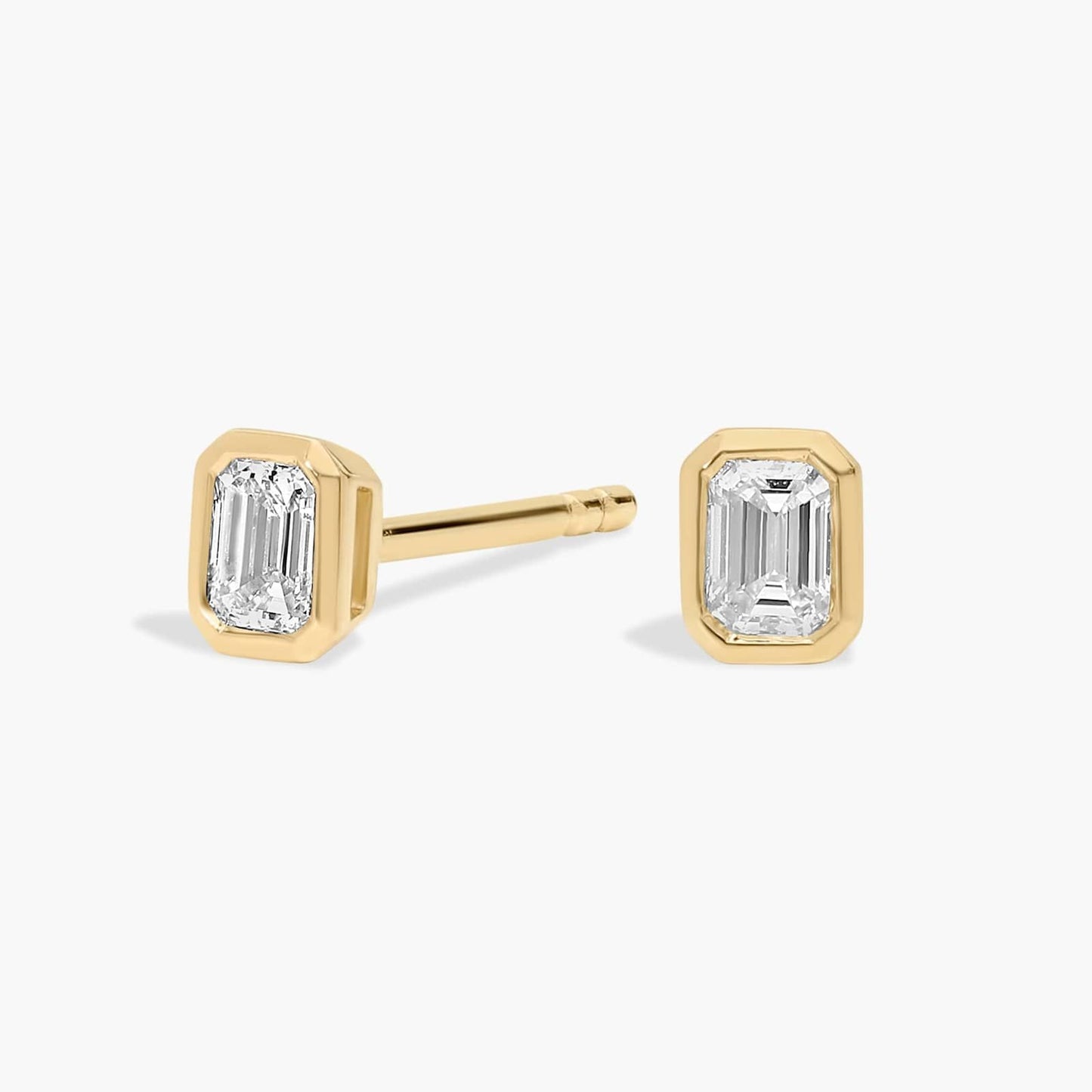 Gold emerald-cut stud earrings on a white background