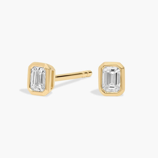 Gold emerald-cut stud earrings on a white background