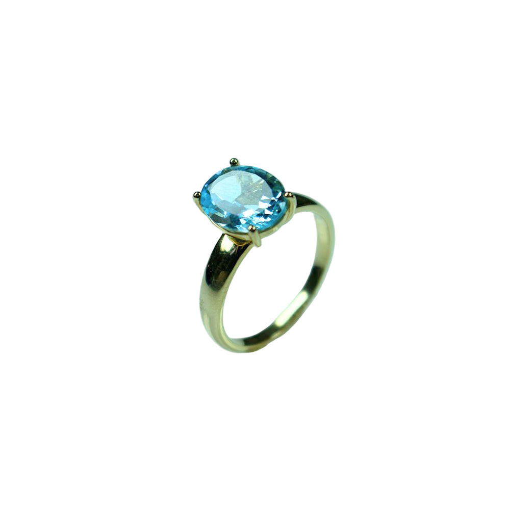 Gold ring with a blue gemstone on a light blue background