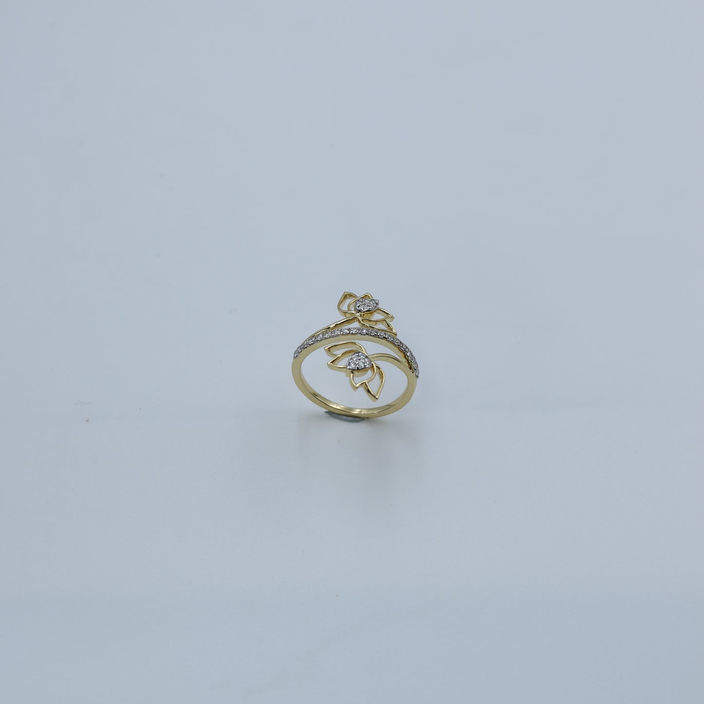 Gold ring with gemstones on a light gray background
