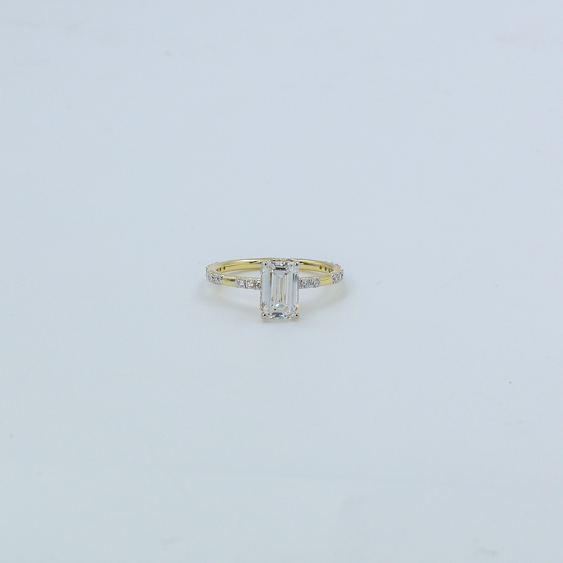 Gold ring with a diamond on a light gray background