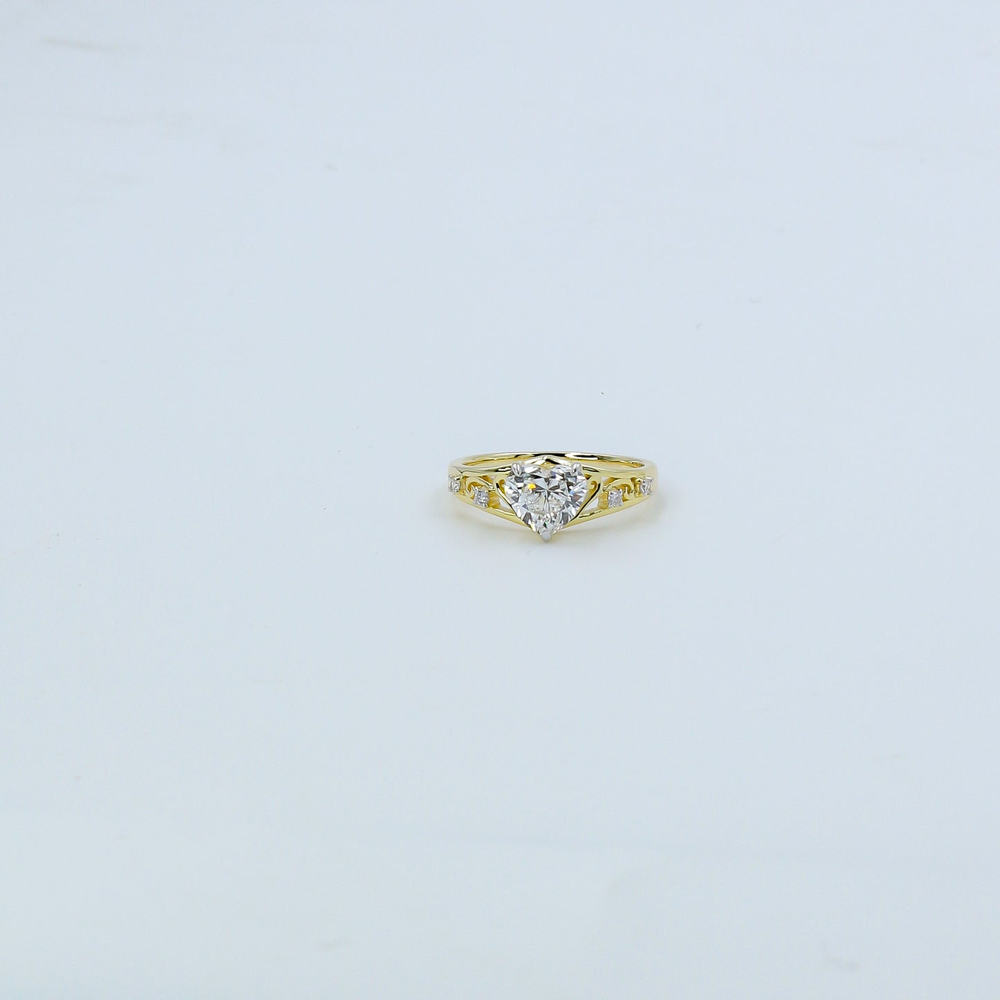 Heart-shaped diamond ring on a light gray background