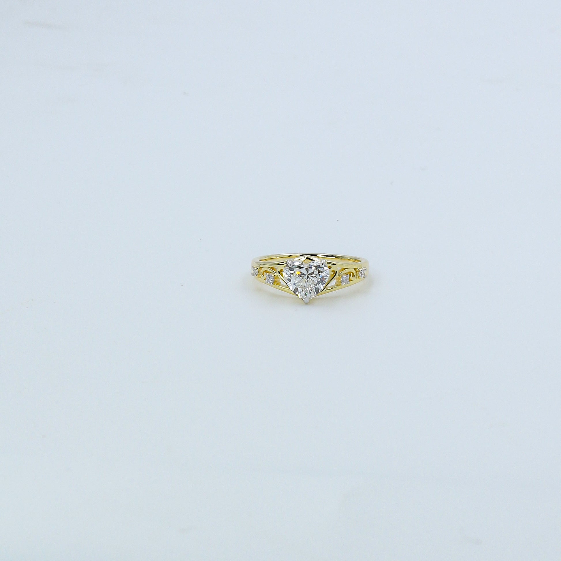 Heart-shaped diamond ring on a light gray background