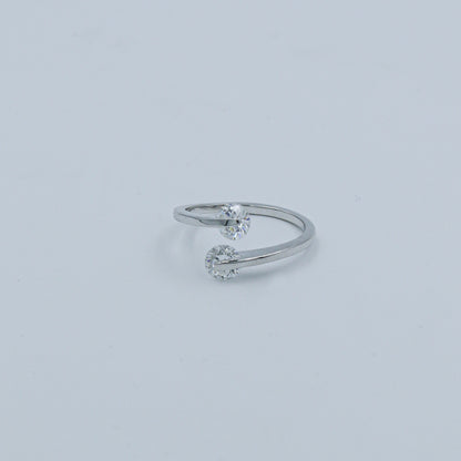 Silver ring with two small diamonds on a light gray background