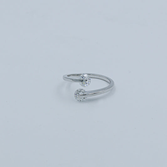 Silver ring with two small diamonds on a light gray background