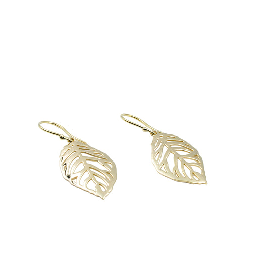 Gold leaf-shaped earrings on a light blue background