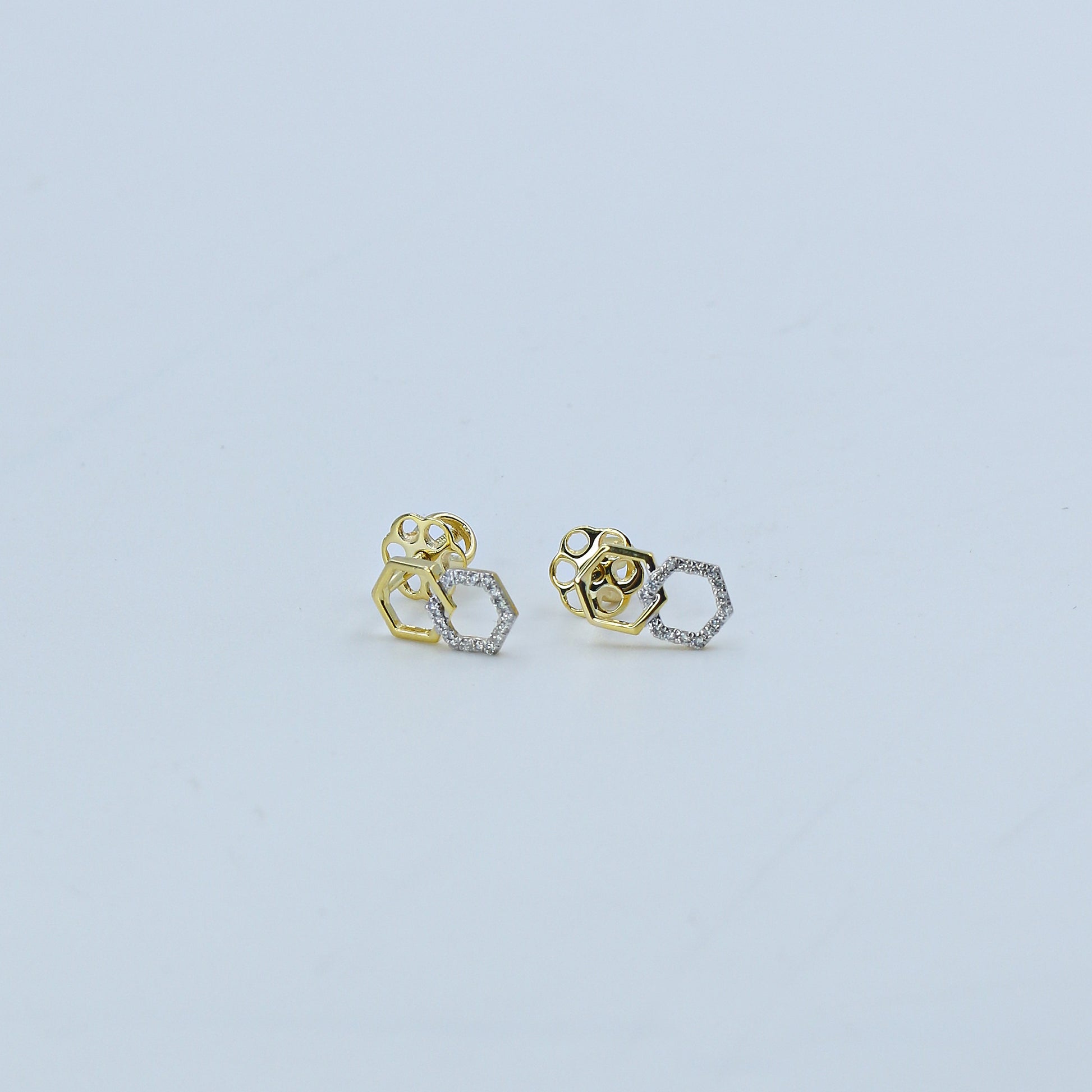 Pair of gold and silver earrings on a light gray background