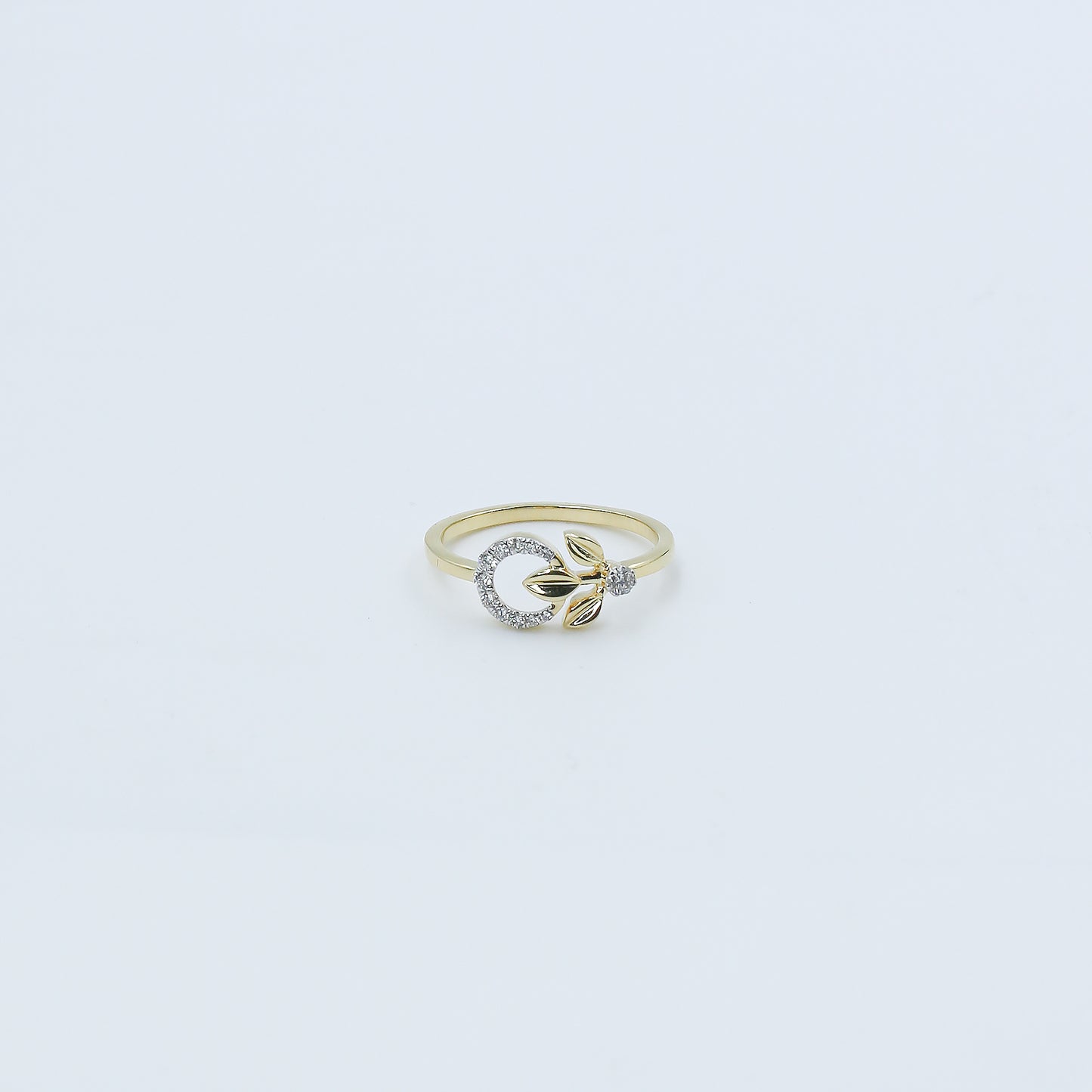 Gold ring with a diamond on a light gray background