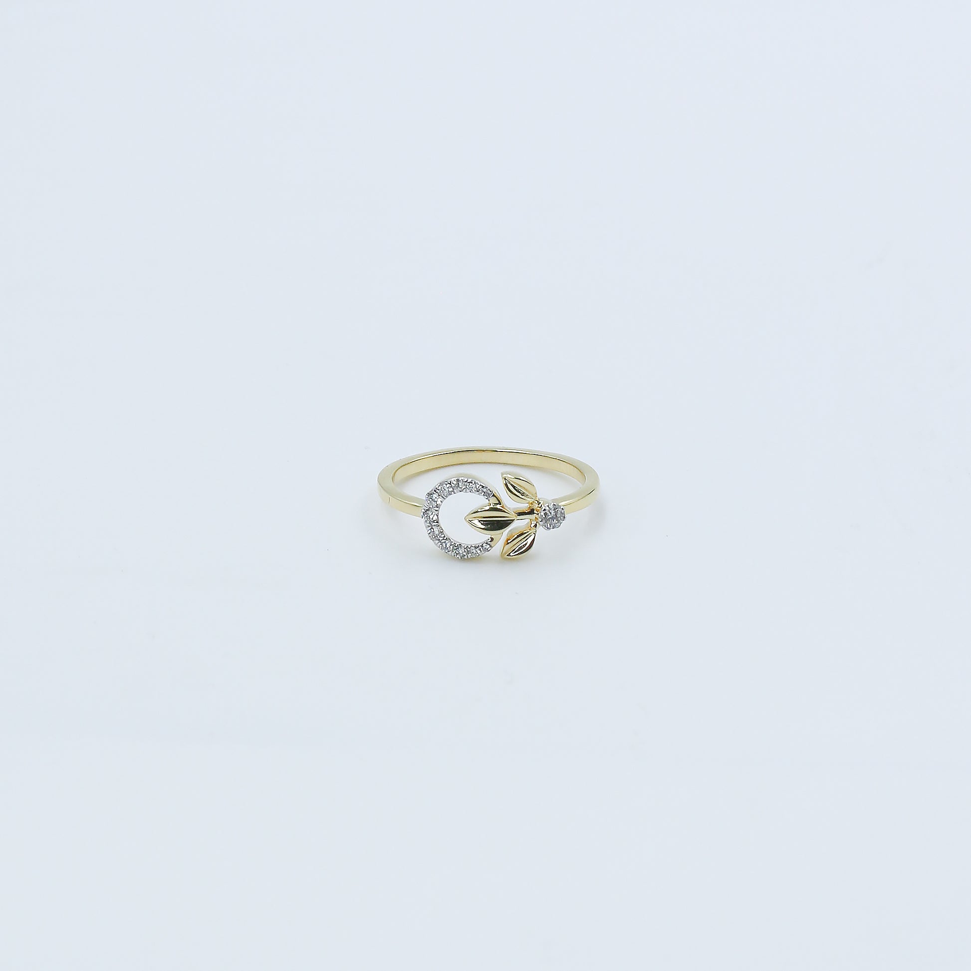 Gold ring with a diamond on a light gray background