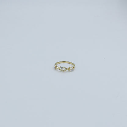 Gold ring with small diamonds on a light gray background