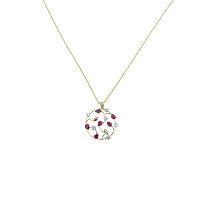 Gold necklace with a circular pendant featuring red stones on a light blue background