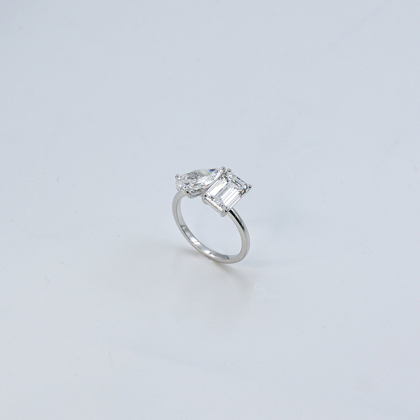 Diamond ring with a rectangular cut gemstone on a light gray background