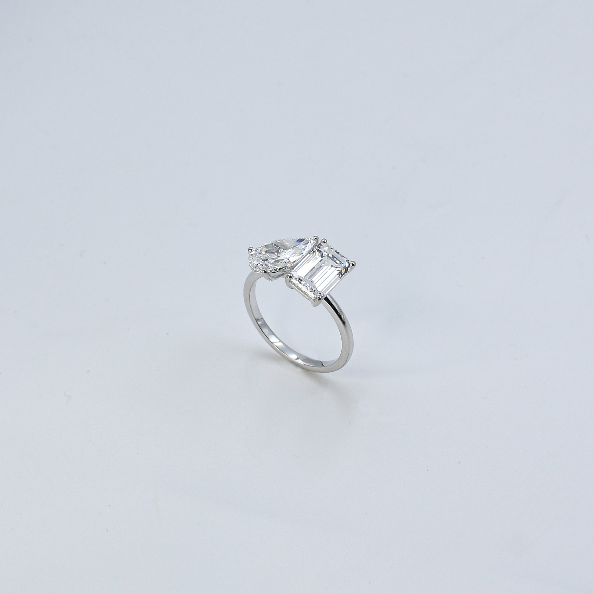 Diamond ring with a rectangular cut gemstone on a light gray background