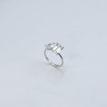 Diamond ring with a rectangular cut gemstone on a light gray background
