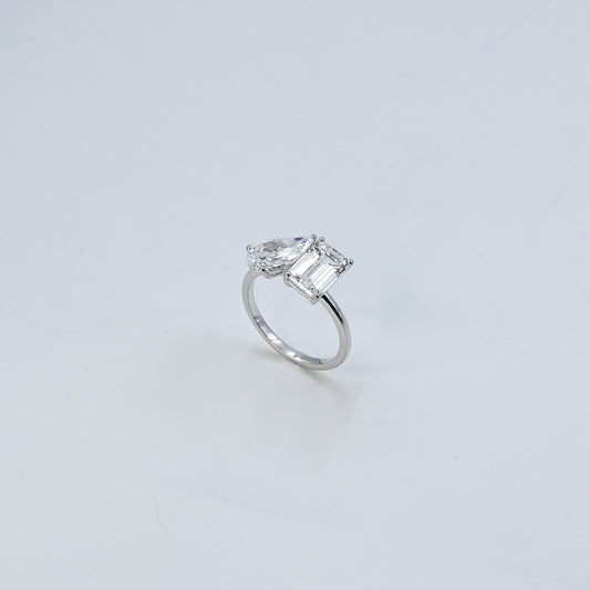 Diamond ring with a rectangular cut gemstone on a light gray background