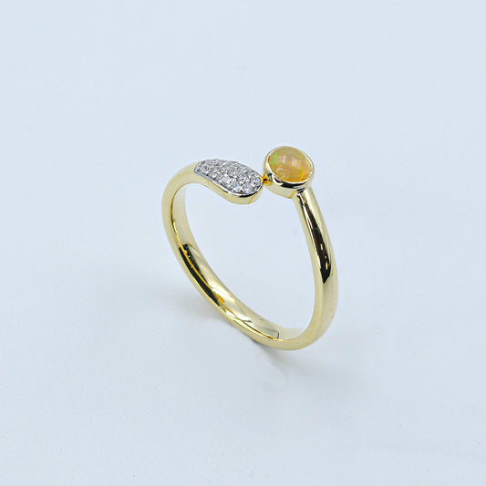 Gold ring with a green gemstone on a light gray background