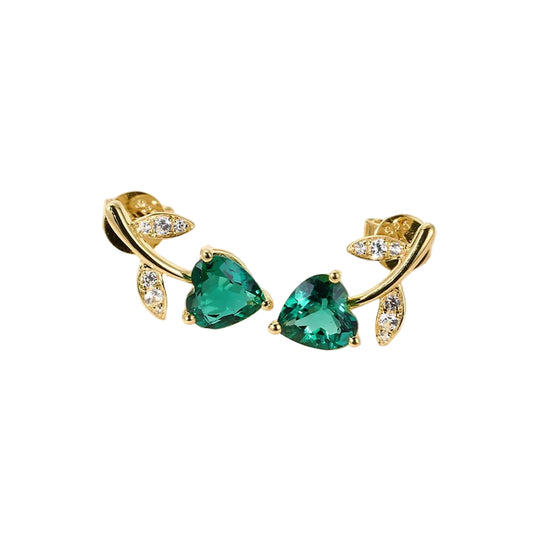 Gold earrings with green gemstones on a light background
