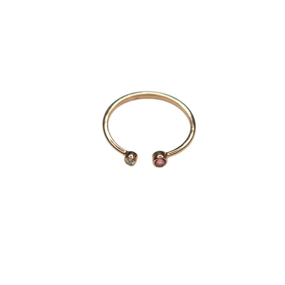 Rose gold ring with embedded gemstones on a light gray background